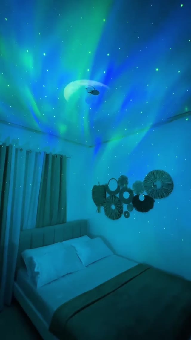 AuroraSky Galaxy Projector casting green and blue aurora light in a bedroom